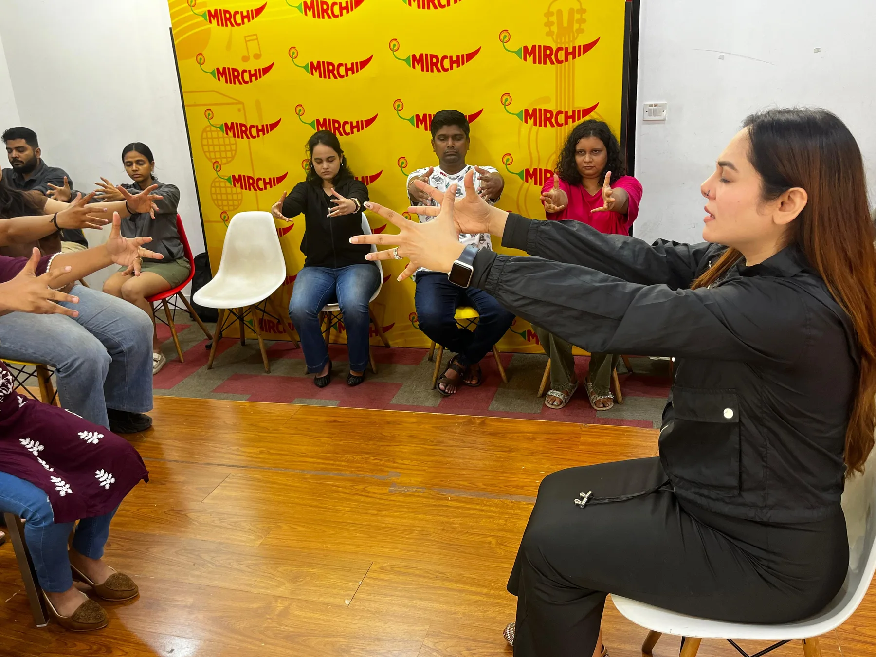 Vibha Jain guiding a group through a seated awareness exercise, with participants focusing on their own responses.