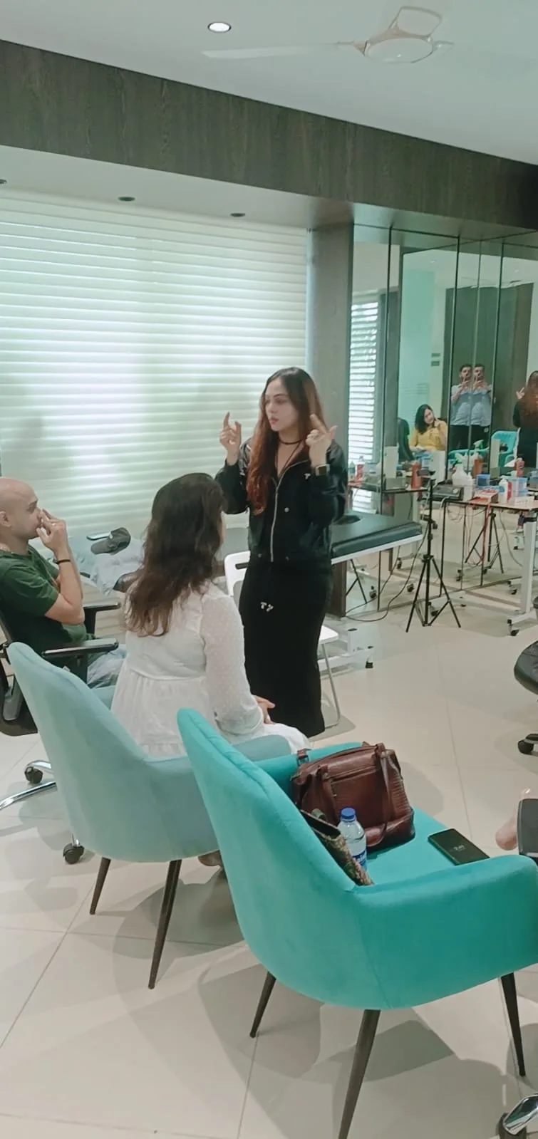 Vibha Jain standing and guiding a small seated group through a relaxation exercise.